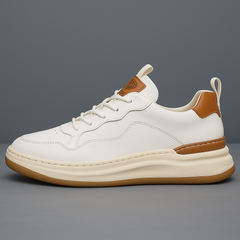 White leather low-top sneaker with lace-up front, tan heel patch, and gum sole
