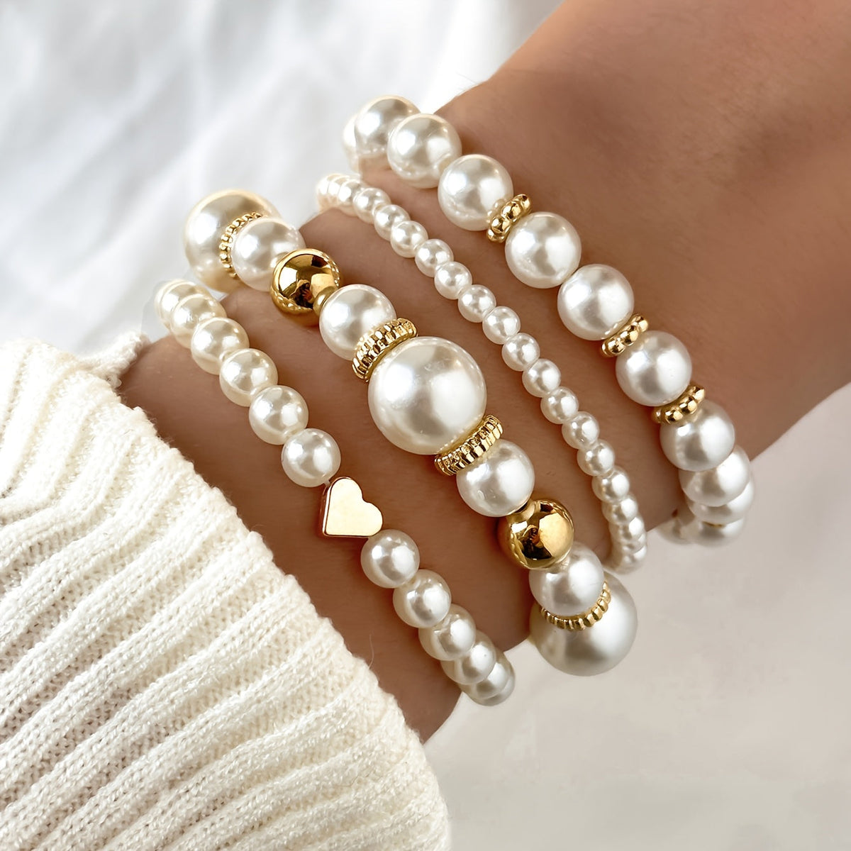 Pearl heart bracelet set on wrist with white beads and gold heart charms