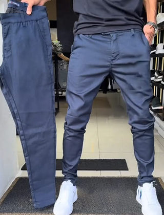 Navy blue slim trousers with tapered legs, button waist, and side pockets