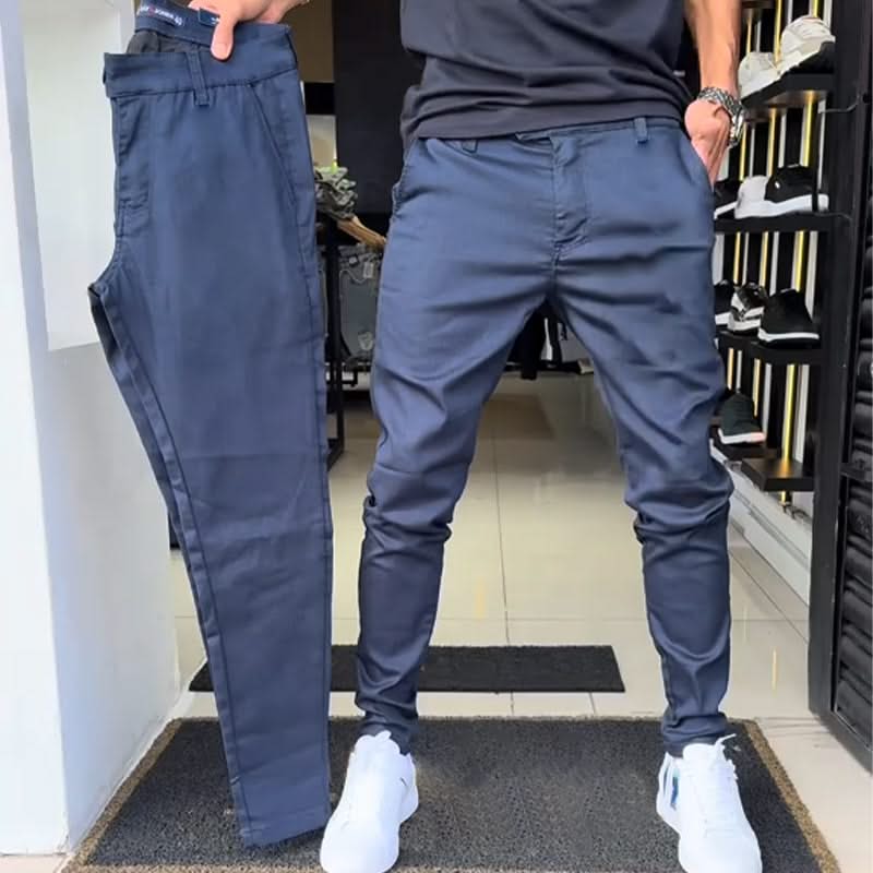 Navy blue slim trousers with tapered legs, button waist, and side pockets