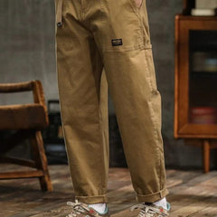 Tan cargo pants with front pleats, side cargo pocket, and cuffed hem