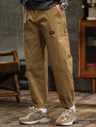 Tan cargo pants with front pleats, side cargo pocket, and cuffed hem
