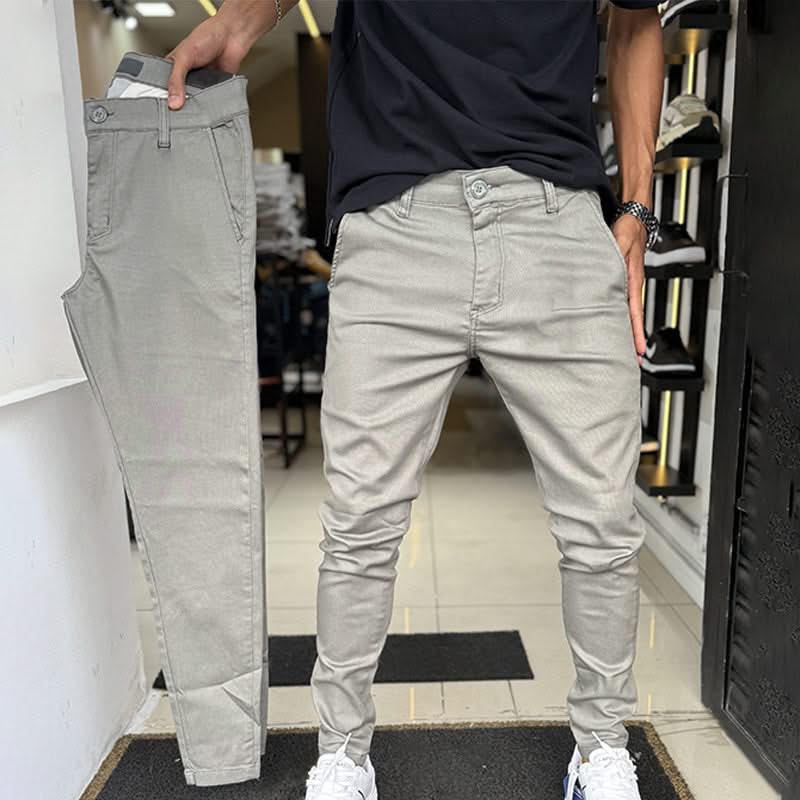 Light grey slim trousers with tapered legs, button waist, and side pockets