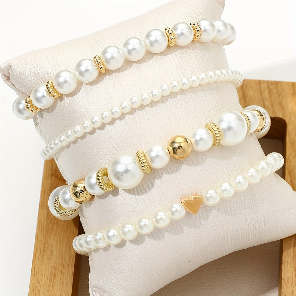 Pearl heart bracelet set on wrist with white pearls, gold beads, and small heart charm