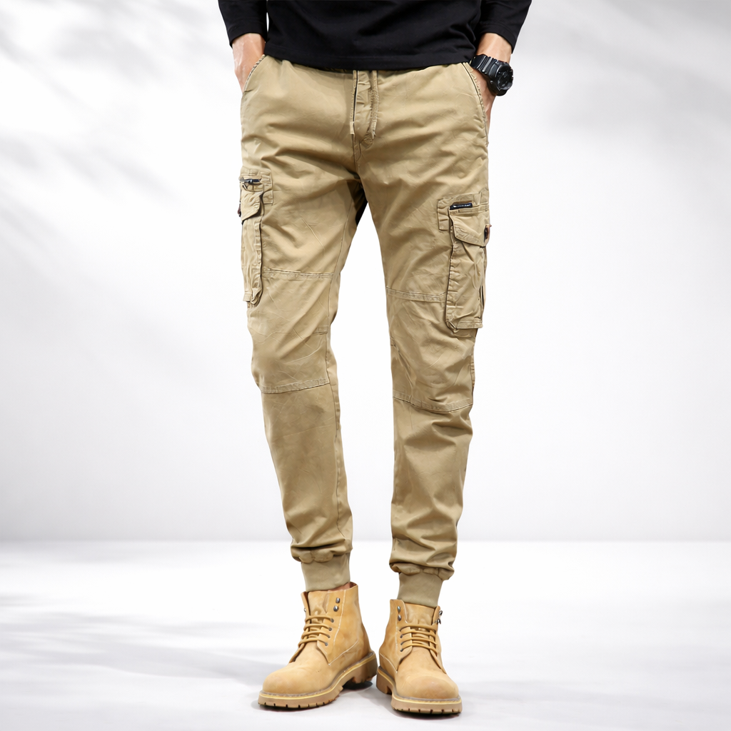 Khaki cargo pants on model, drawstring waist with cuffed ankles and cargo side pockets