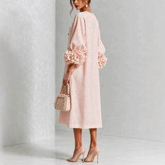 Pink floral midi dress in side view with button front and rose-cuff sleeve details