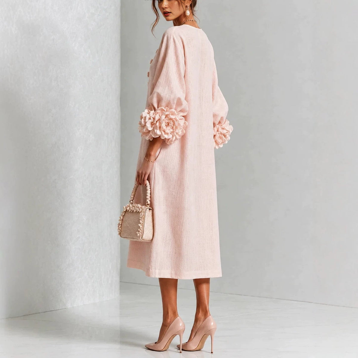 Pink floral midi dress in side view with button front and rose-cuff sleeve details