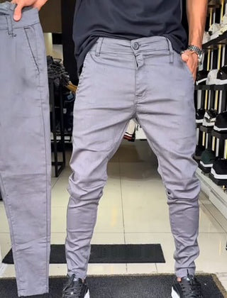 Grey slim trousers with tapered legs, button waist, and side pockets