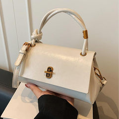 White leather-look crossbody shoulder bag with gold-tone clasp and top flap