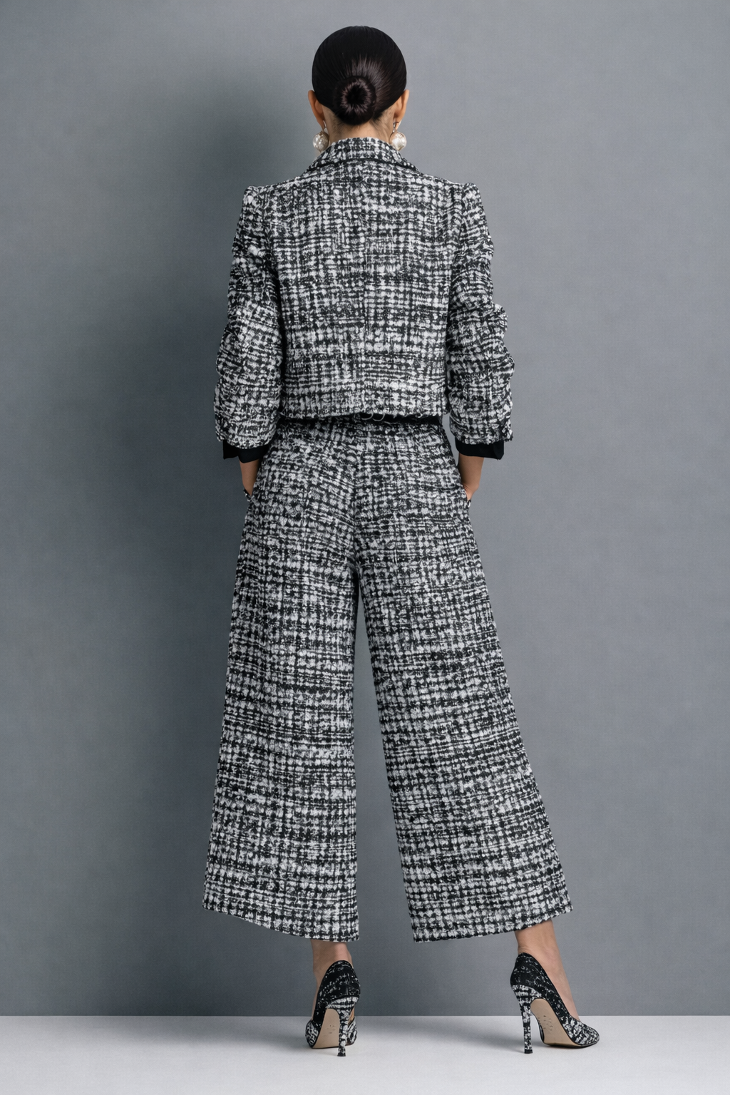 Back view of black-and-white tweed blazer and wide-leg trousers set with belt