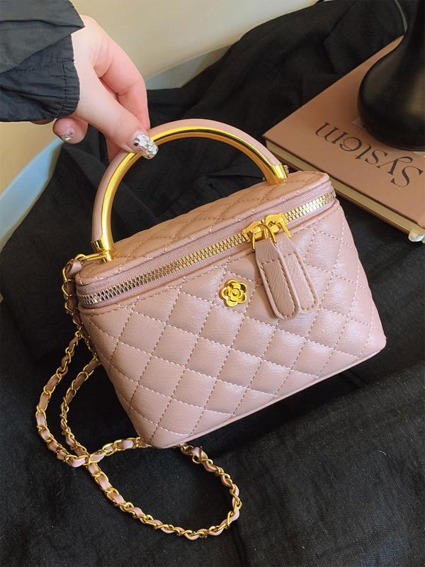 Blush pink quilted crossbody bag with gold-tone chain, top zip, and flower detail