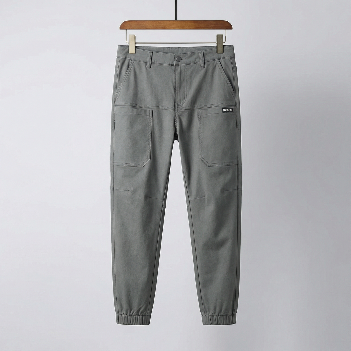 Grey stretch utility pants with drawstring waist, button fly, and cargo pockets