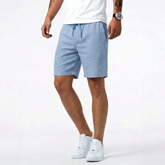 Blue summer shorts with drawstring waistband and side pockets, worn with sneakers
