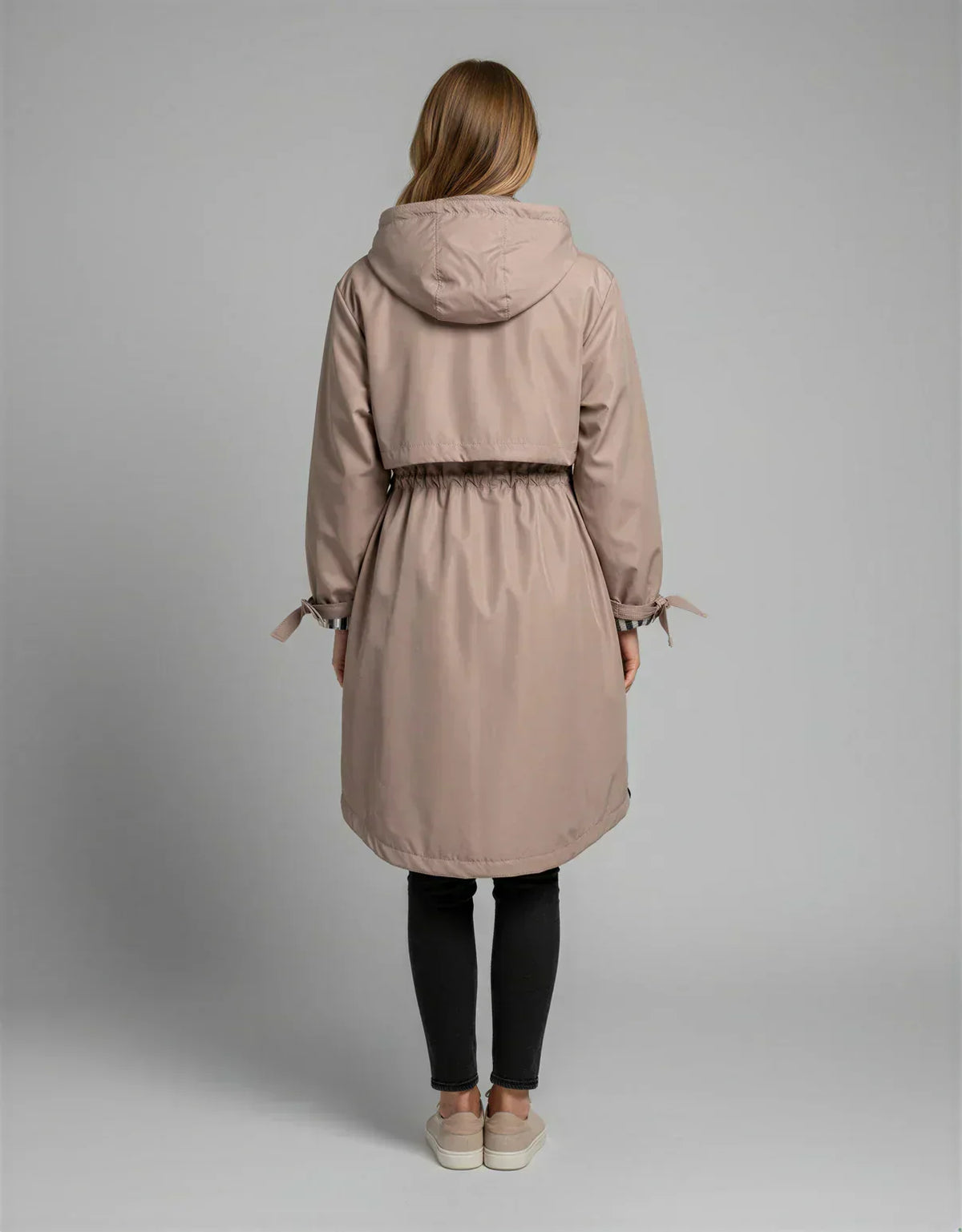 Women's taupe hooded waterproof jacket, back view with cinched waist