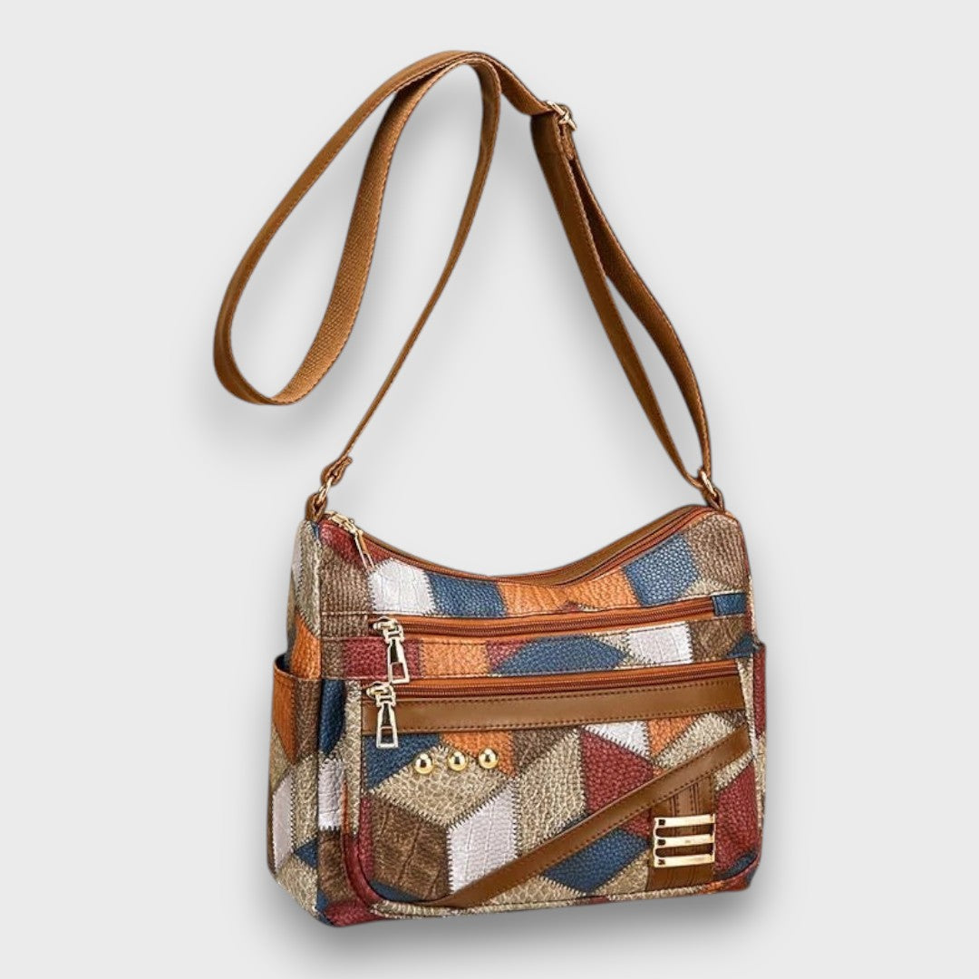 Patchwork leather small shoulder bag with top zip, front pocket, and braided strap handles