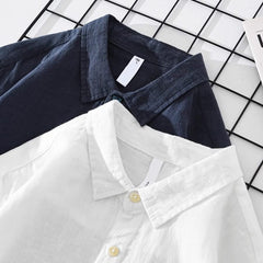 Navy and white collared button-up shirts with chest pockets, long sleeves