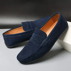 Suede loafers in navy with strap detail, moc stitching, and orange-brown lining