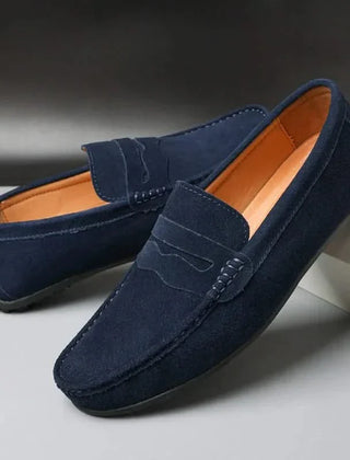 Suede loafers in navy with strap detail, moc stitching, and orange-brown lining