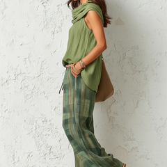 Side view: olive sleeveless cowl tunic paired with green plaid wide-leg pants