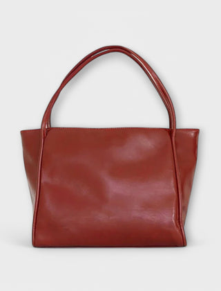 Red leather-look tote bag with wide top handles and smooth rectangular front