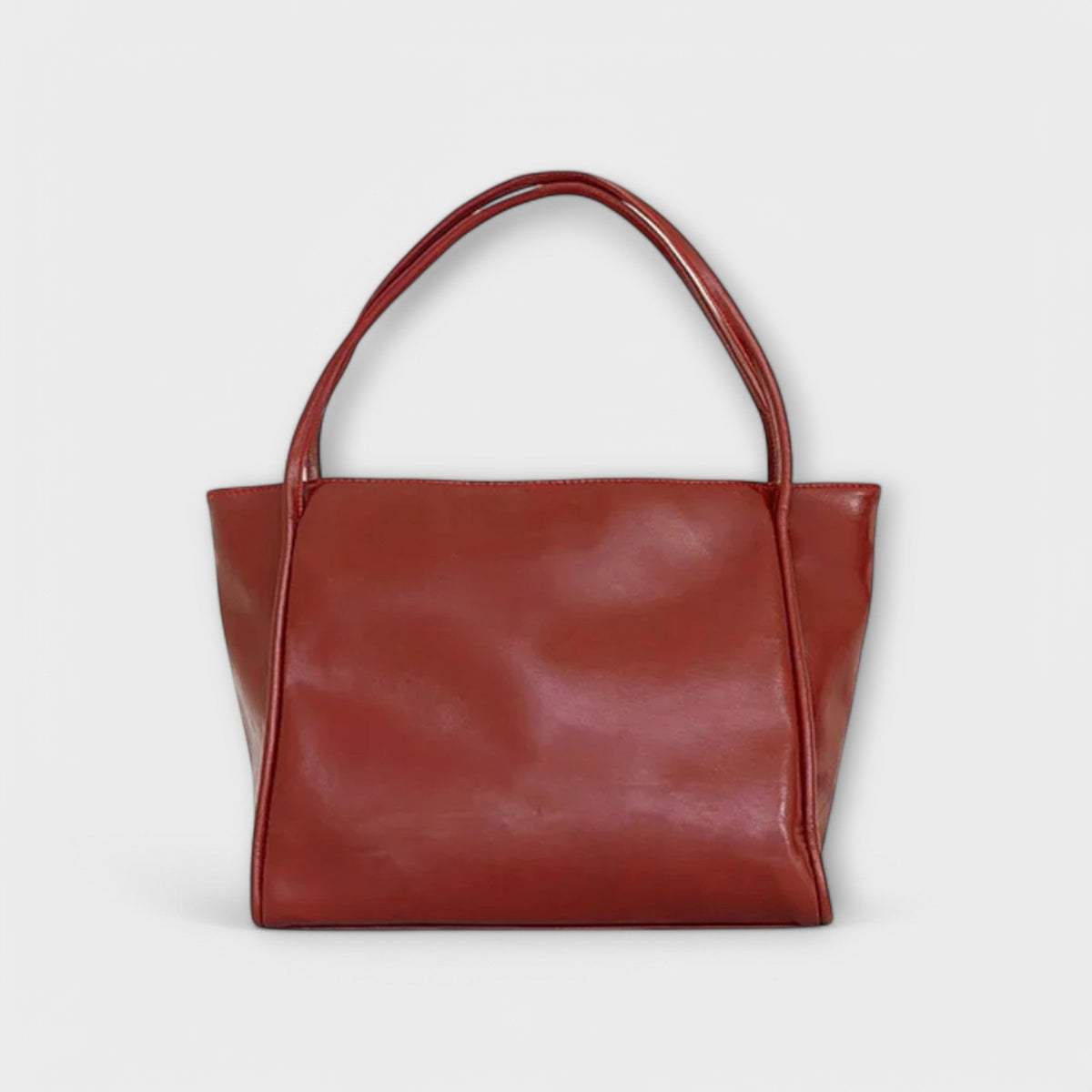 Red leather-look tote bag with wide top handles and smooth rectangular front