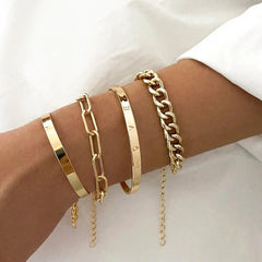 Gold-tone bracelet set with cuff and chain-link bangles on a wrist
