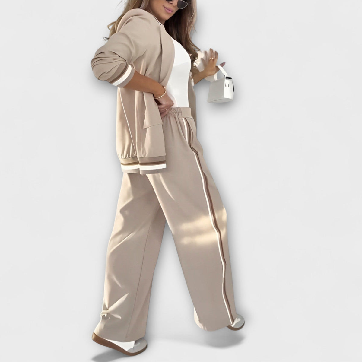 Beige two-piece blazer and trouser set with striped hem trim and smooth wide-leg fit.
