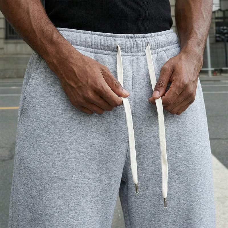 Close-up of light grey waistband with two white drawcords and stitched elastic seam