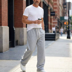 Light grey drawstring pants with relaxed leg and elastic waist, worn with white sneakers