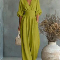 Lime green V-neck high-waisted jumpsuit with draped sleeves and flowy wide-leg pants