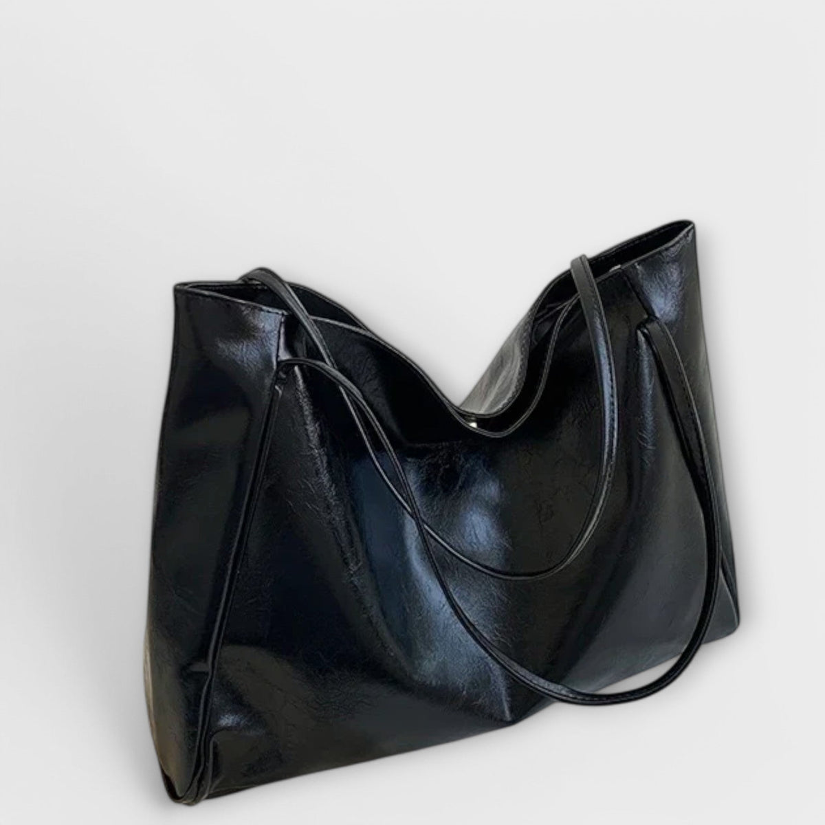 Dark glossy leather-look tote bag with curved top opening and wide handles
